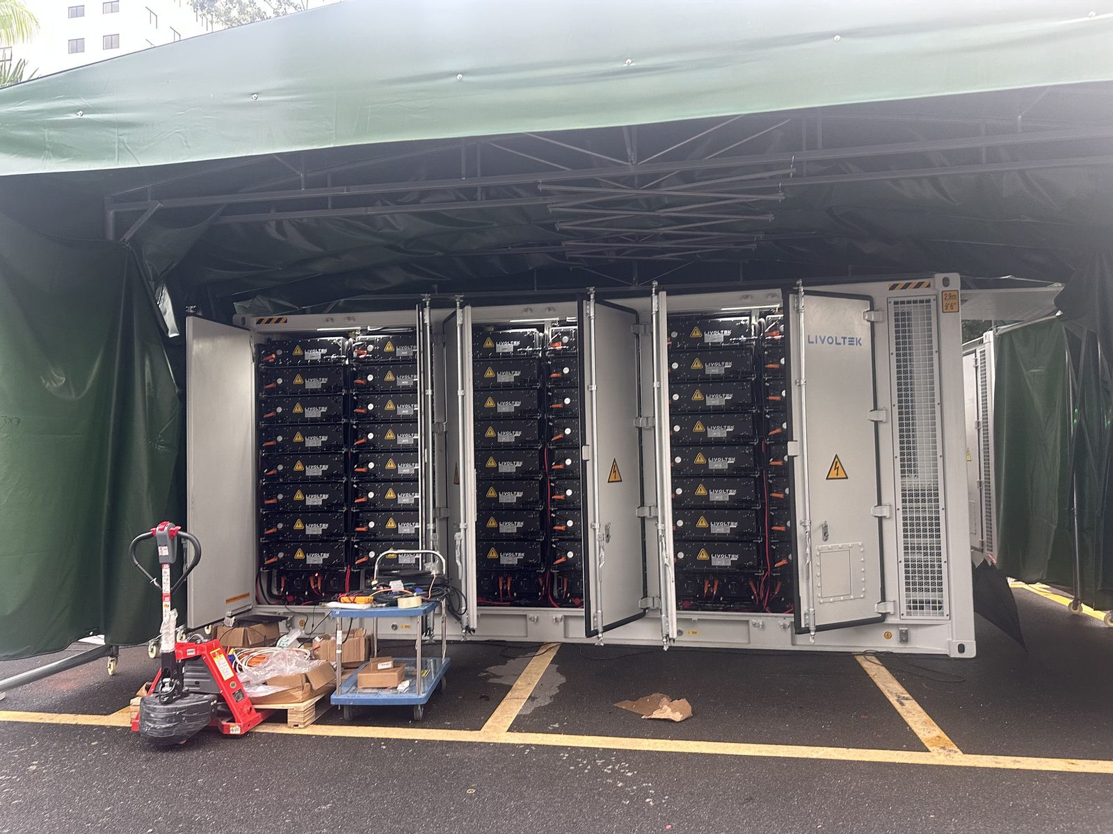 Battericontaineren med dørene åpne og batterimoduler stablet i rack